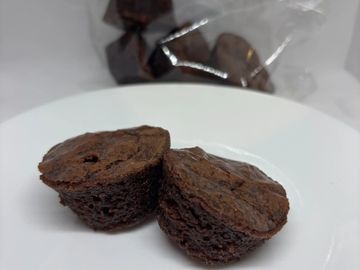 Two halves of a chocolate brownie on a white plate.
