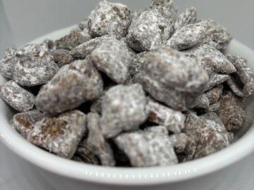 Bowl of chocolate-covered pretzels dusted with powdered sugar.
