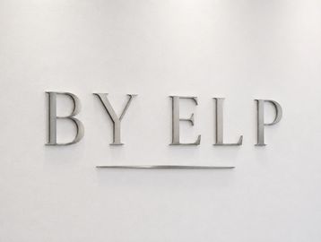 Elegant wall text reading 'BY ELP' with a minimalist underline on a white background.