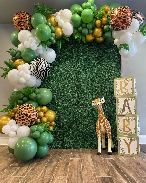 Jungle-themed baby shower decoration with balloons and giraffe.