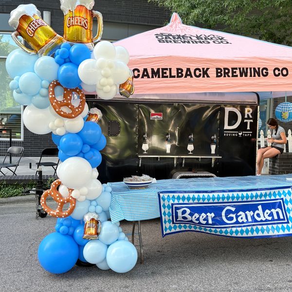 Beer garden booth with festive balloons and pretzels.