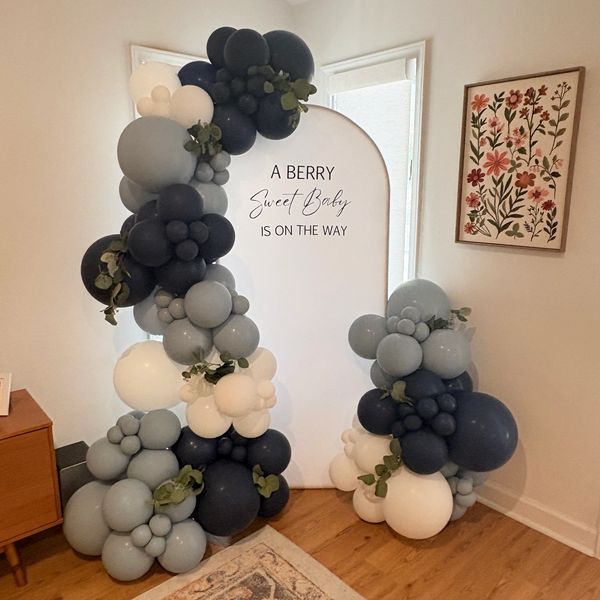 Balloon decoration for a baby shower with a sign.