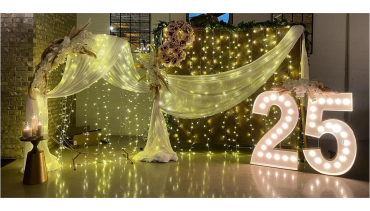 Elegant 25th anniversary decoration with lights and flowers.