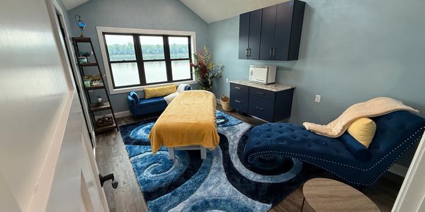 Serene spa room with blue accents and a lake view.