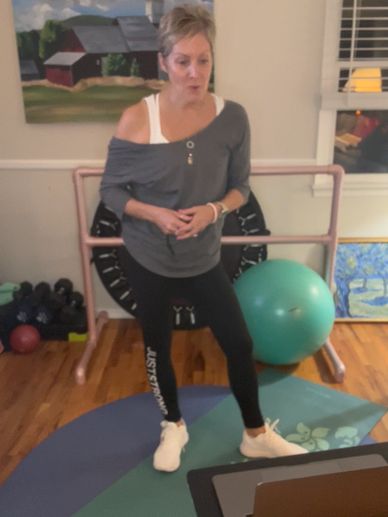 Woman exercising indoors with fitness equipment.