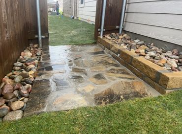 Flagstone, river rock, chopped stone border, drainage installation  back side gate 
