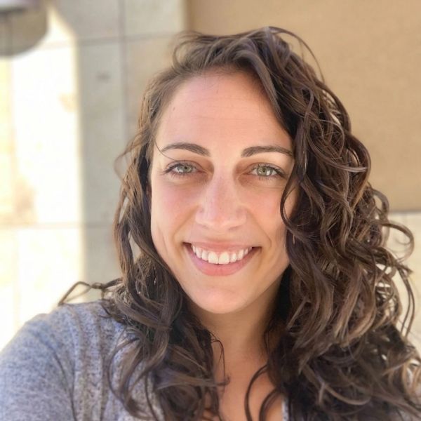 Smiling woman with curly hair.