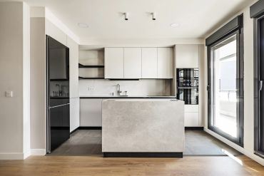 Modern minimalist kitchen with black and white cabinetry and a central island.