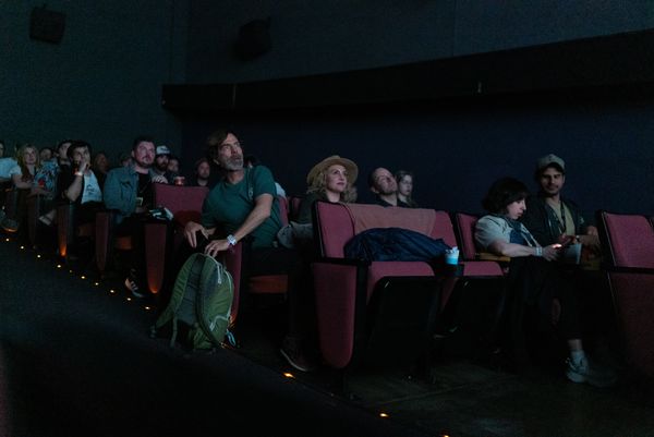 Audience watching a movie in a dark theater.