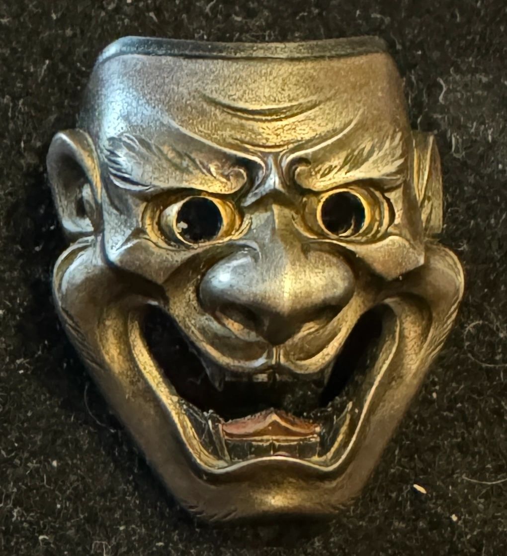Netsuke in the form of a hornless Hannya mask with gold eyes, copper tongue and shakudo hair. After Hamano Shozui (Masayuki). Meiji era