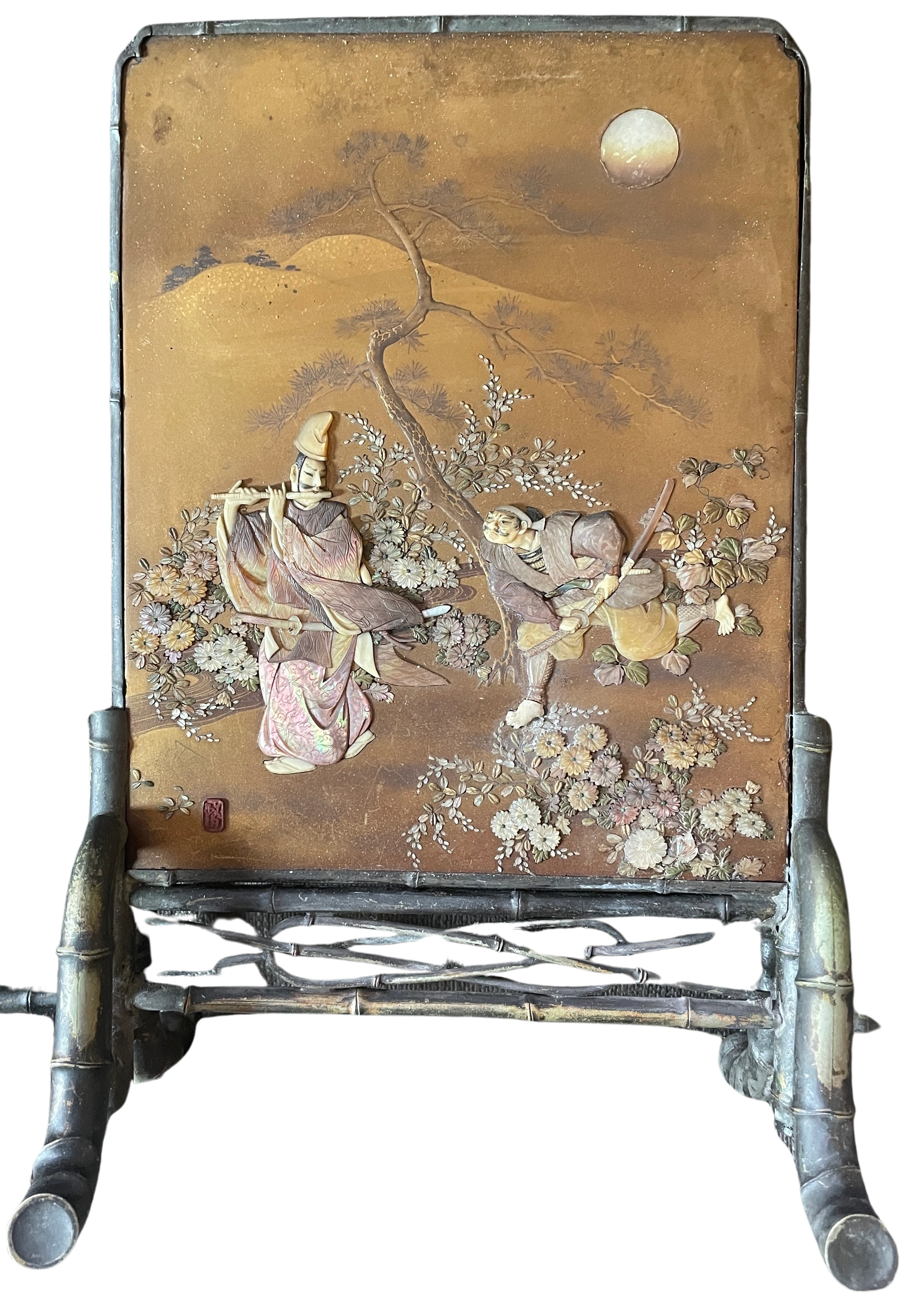 Shibayama table screen depicting the nobleman Fujiwara Yasumasu (958-1037) playing the flute at the Ichihara moor as he is stalked by the bandit Hakamadare Yasuyuki (Kidomaru), intent on stealing Fujiwara’s robe. Kidomaru becomes enchanted by the music and desists. Set against a gold ground in hiramaki-e, takamaki-e & kirikane lacquer on a nashiji ground in a silver frame with shibuichi decoration. Signed Masayuki in a tsuishu red lacquer reserve with metalwork by Ryuun. Meiji era.