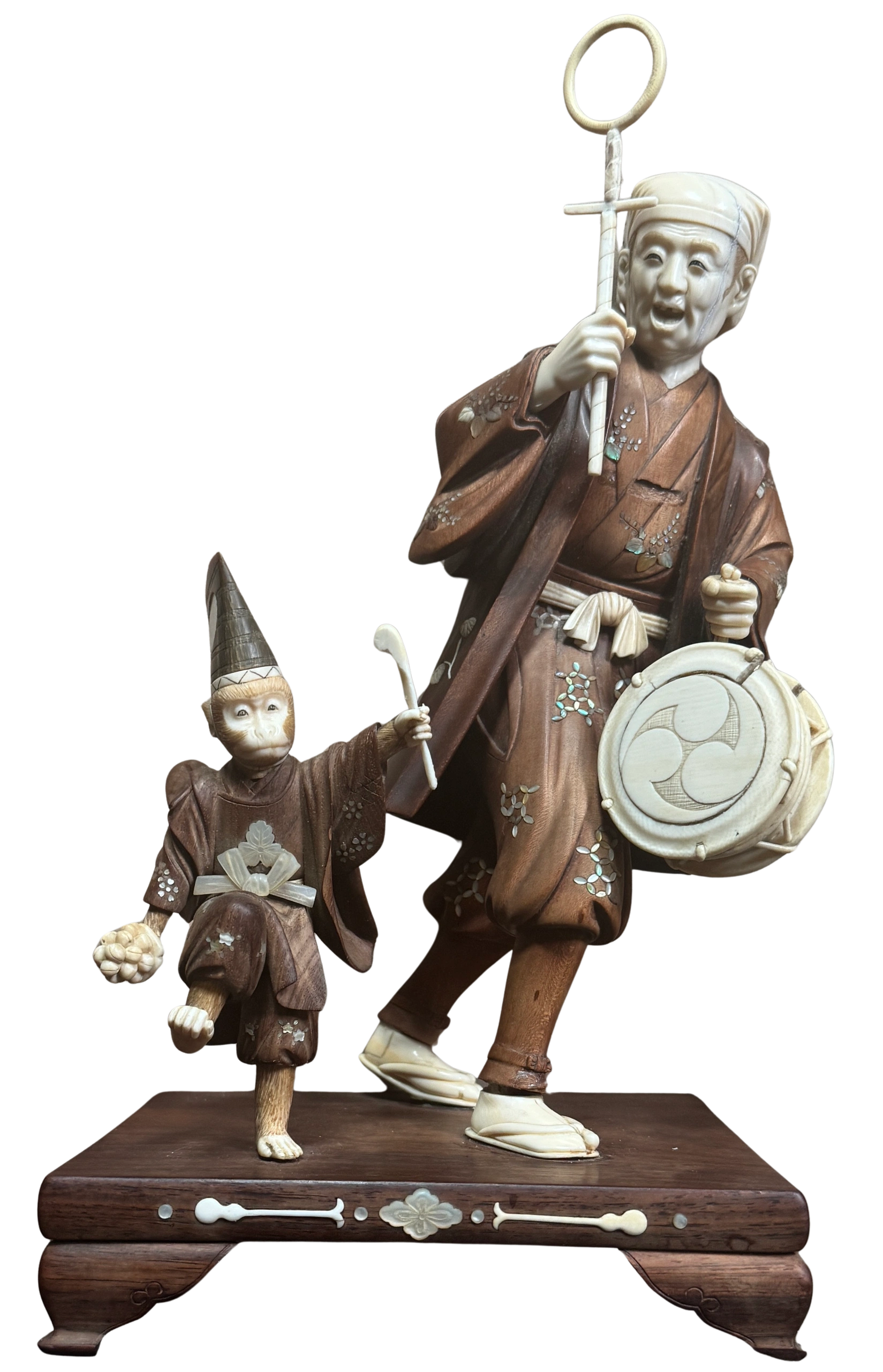 Sarumawashi (monkey trainer) with guiding staff, the monkey wears a saruni eboshi (court hat) and waves a drum stick. Boxwood & ivory figures both signed in mother of pearl reserves by Tsuneaki. Meiji era.