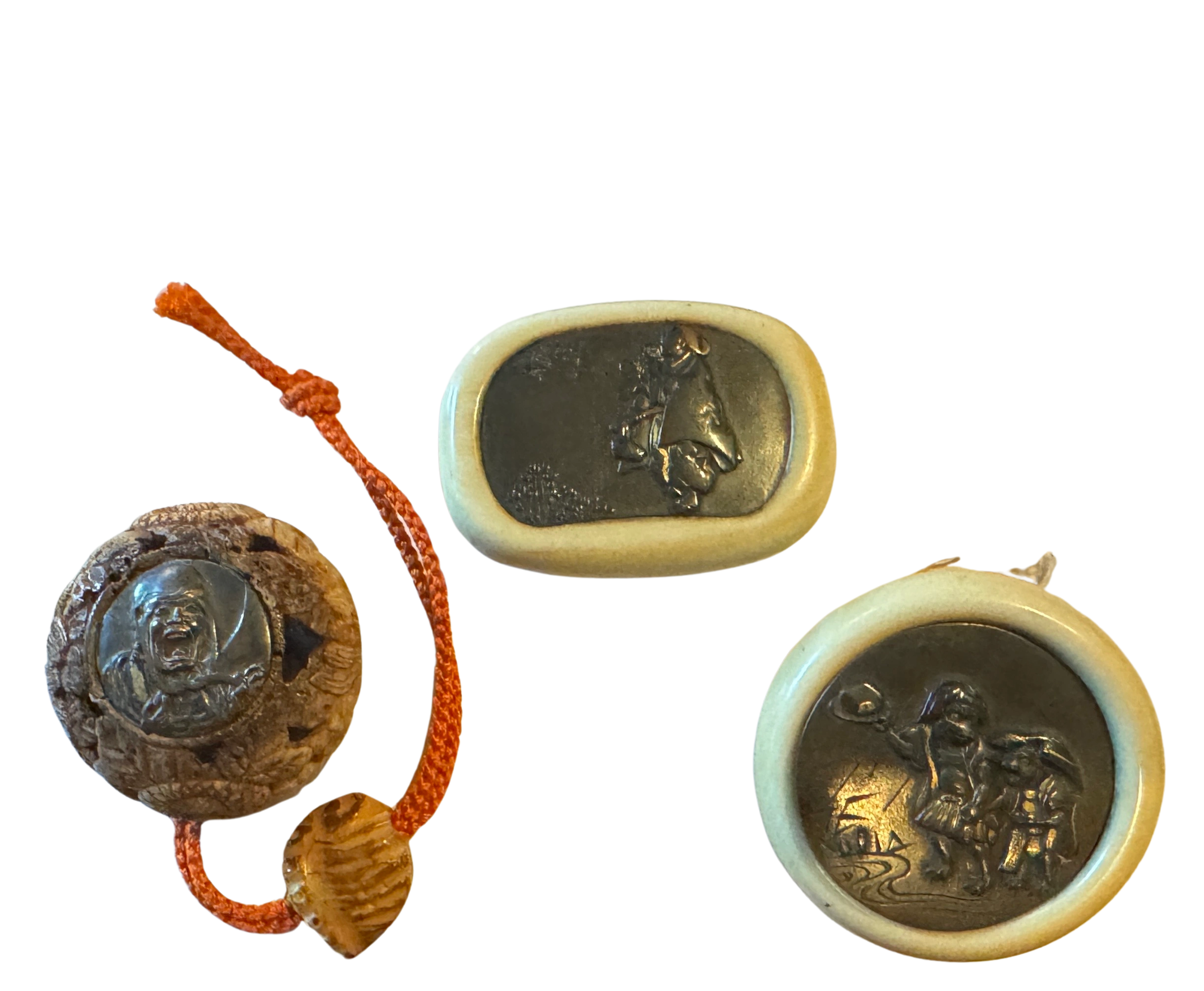 Kagamibuta (‘mirror lid’) netsukes, two in ivory and one in deer horn set with shakudo, copper, gold & silver motifs depicting Raken Inkada Sonja, the Buddha disciple with long eyebrows. Edo era.