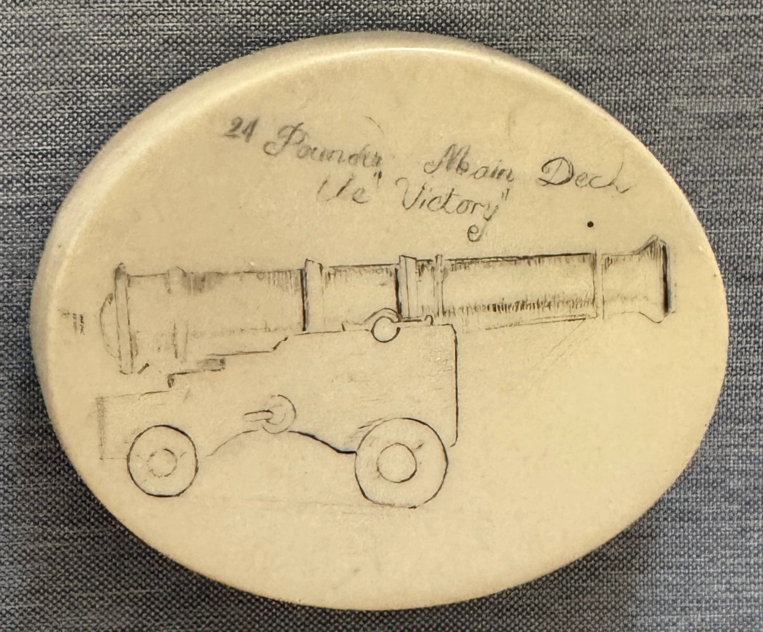 HMS Victory Trafalgar artifact - Scrimshaw medallion depicting a main deck canon and hand inscribed: 24 Pounder Main Deck the “Victory”