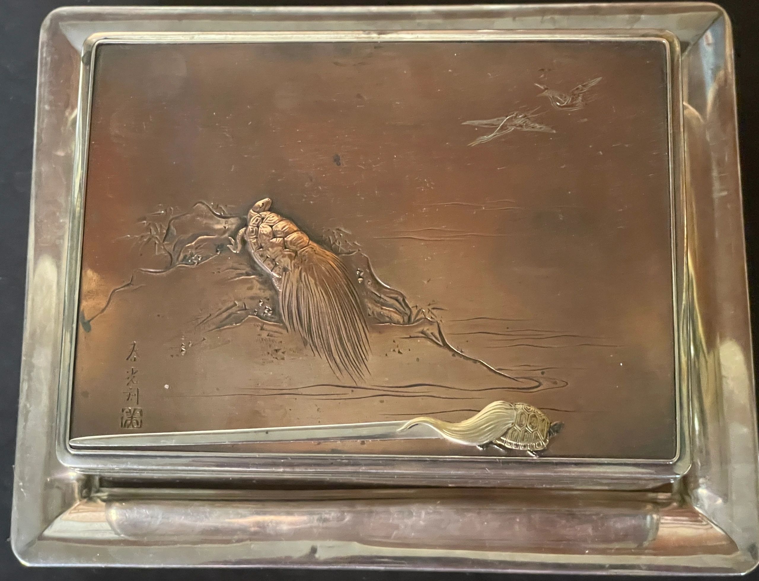 Mixed metal kobako depicting a Minogame (mythical turtle of longevity), viewing cranes. Ei seal for Miyao Eisuke together with a silver kanzashi (hair ornament) with gold decoration, depicting a Minogame; a motif often used on articles commemorating the 25th wedding anniversary of Emperor Mutsushito, March 1894.