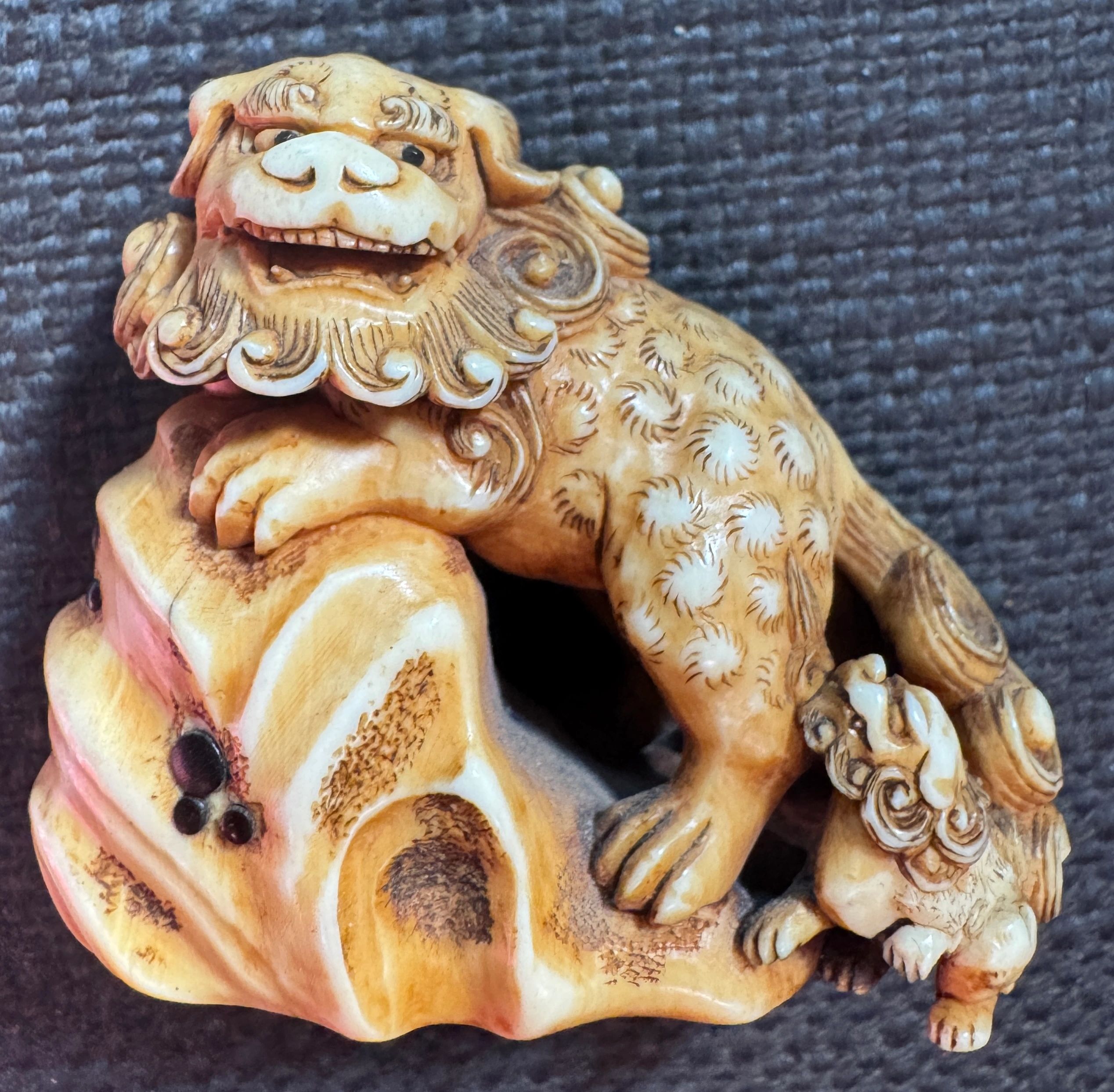 Ivory netsuke depicting a shishi with a shishi pup, signed Masamine. Late Edo era.
