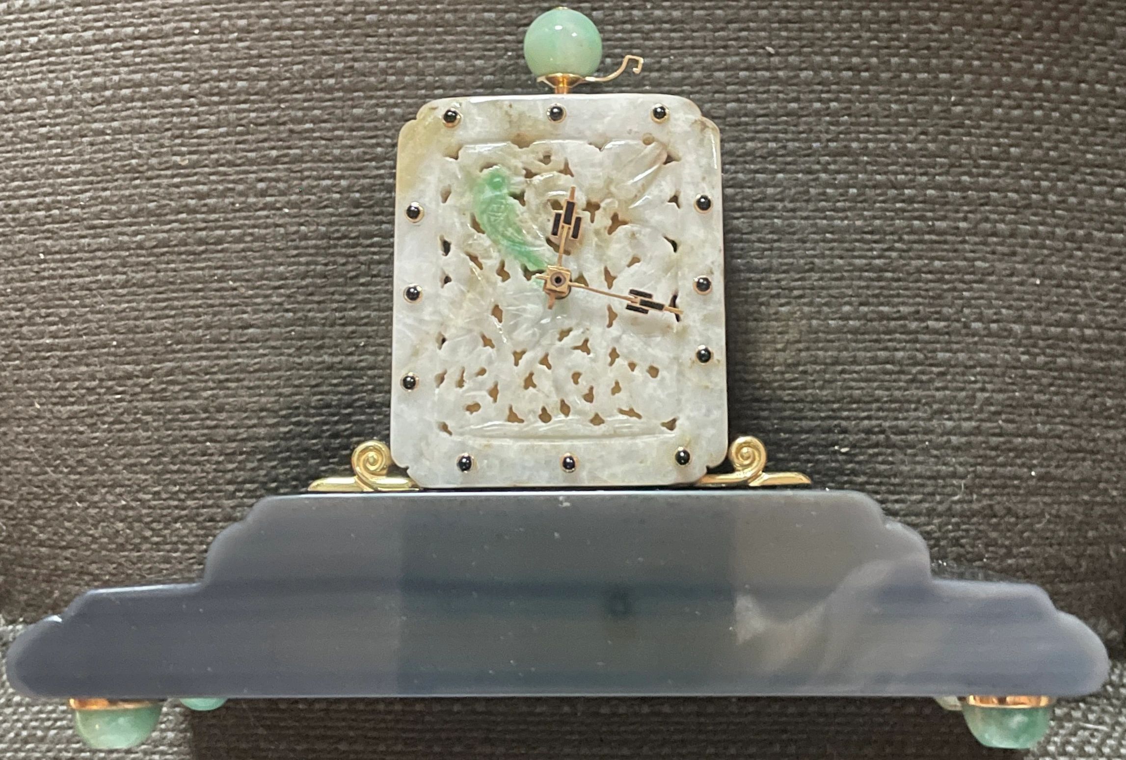 Clock set in antique Chinese jadeite plaque with green parrot accent, on a gold and onyx base, gold mounted jade feet & onyx hour indicators with enameled gold hands. 9 day going lever movement (12 ligne - 6.7) signed LUTZ FRANCE (Jean Lutz, active 1917-1937). Lacloche Freres, Paris c.1920
