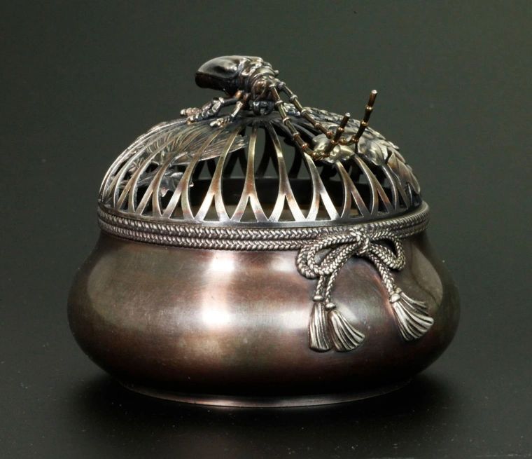 Silver koro formed as a sack with tassels surmounted by a long horn beetle finial. Artr. Jomi Eisuke, Meiji era.