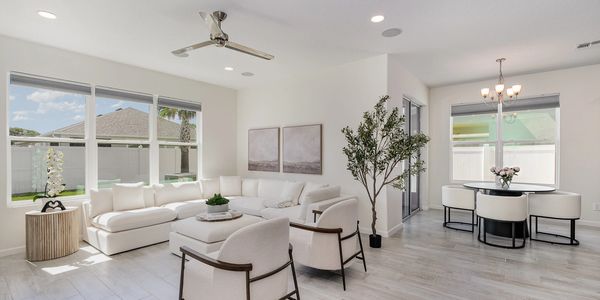 Bright modern living room with white furniture and large windows.