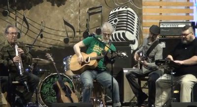 Four men playing instruments in a music setting.
