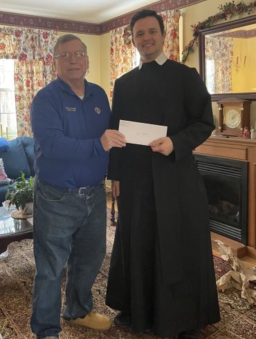 Two men exchanging an envelope indoors.
