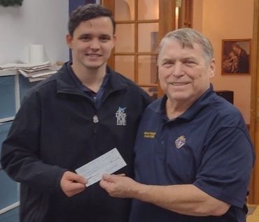 Two men smiling and holding a check.