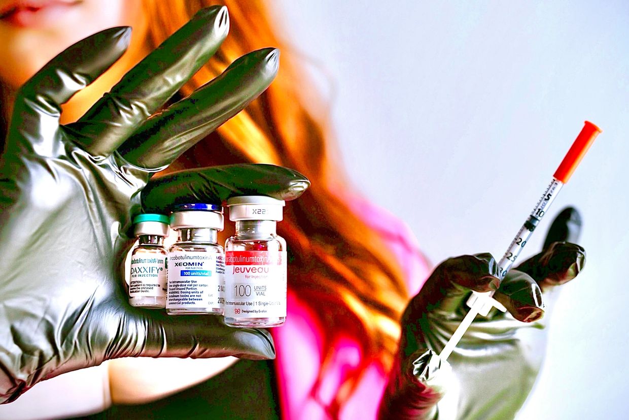 Brook holding a syringe and bottles of Daxxify, Xeomin and Jeuveau