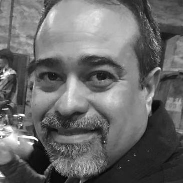 Black and white close-up portrait of a middle-aged man smiling.