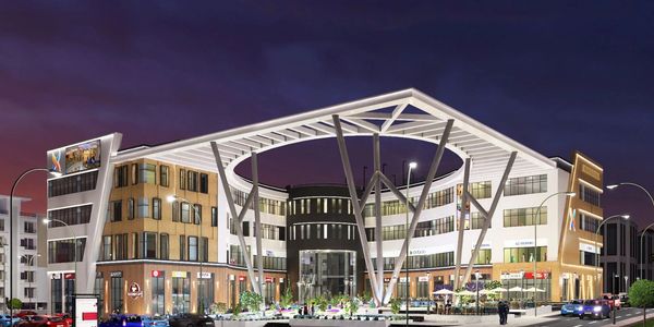 Modern commercial building with a distinctive circular roof structure at night.