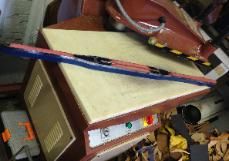 A thermal heat press machine with a blue and red handle.
