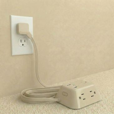Creative power strip design with cord neatly coiled and plugged into wall outlet.