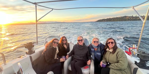Five friends enjoying a boat ride at sunset.
