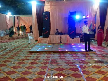 Indoor event space with stage and colorful lights.