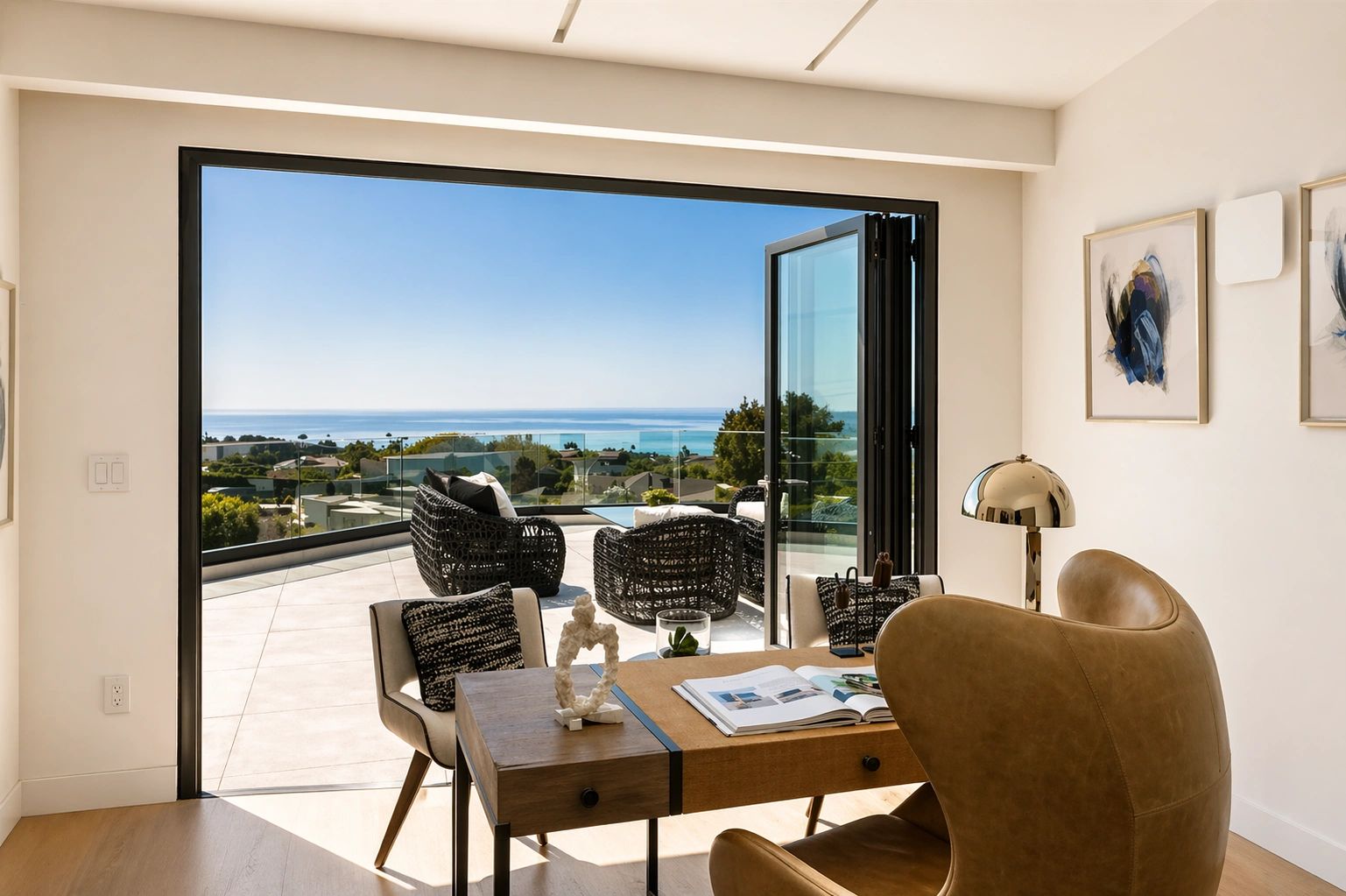 Modern home office with ocean view and outdoor seating on terrace.