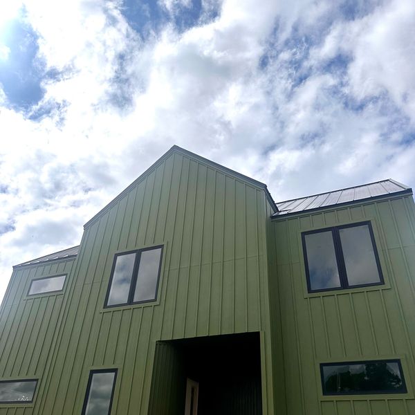 Photo of a modern green 2 story house.
