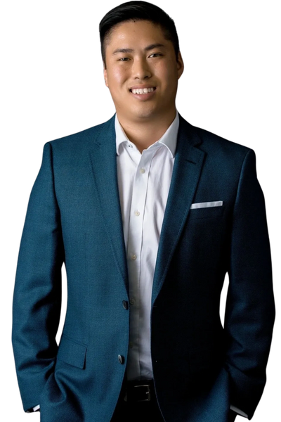 Smiling man in a blue suit jacket and white shirt, standing confidently.