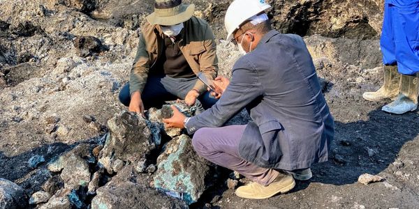 Two people examining rocks at a mining site.