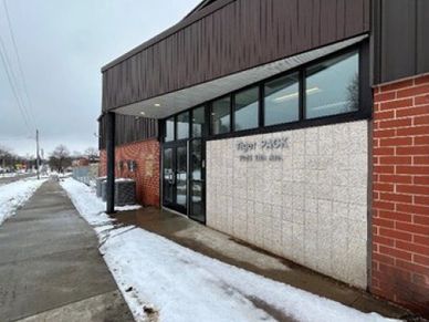 Exterior of a post office building with snow on the ground.
