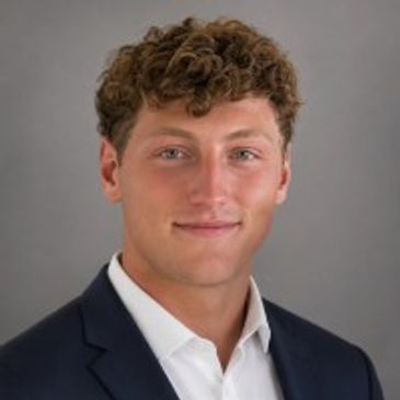 Professional headshot of a young man in a suit.