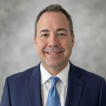 Professional man smiling in a suit and tie.