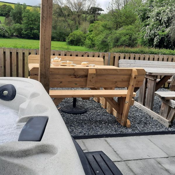 Wooden benches and afternoon tea set up with countryside views.