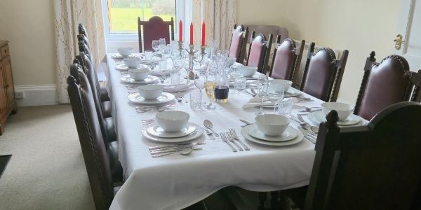 Elegant dining table set with white tablecloth and red candles.