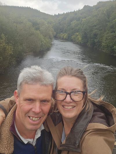 Picture of Neil and Becky the faces behind The Elms holiday home with a beautiful background scene.