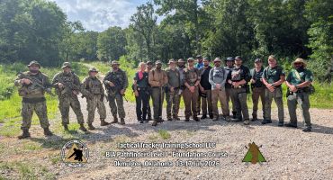 Group photo of tactical training participants outdoors.