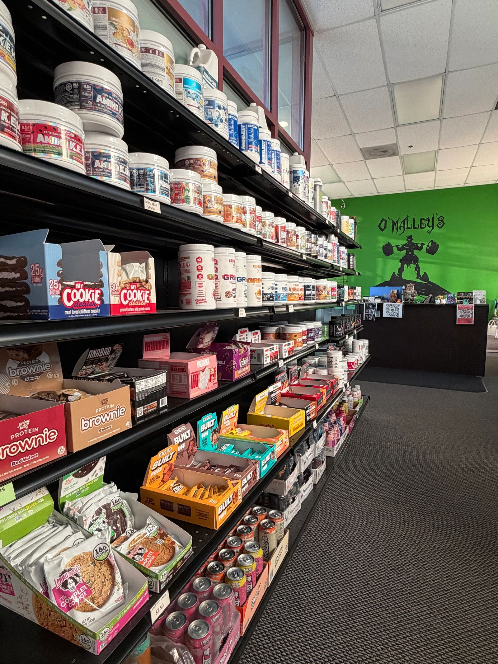 Supplement shelves stocked with protein and pre-workout