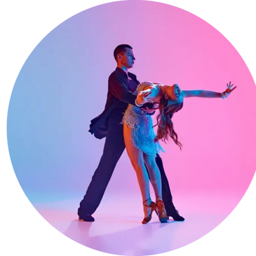 A couple performing a graceful dance pose with colorful lighting.