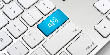 Keyboard with a blue mute/unmute key highlighting audio control.
