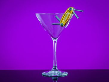 Martini glass with a Lezyne multi-tool with purple backround