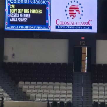 Scoreboard shows event details in an empty arena.