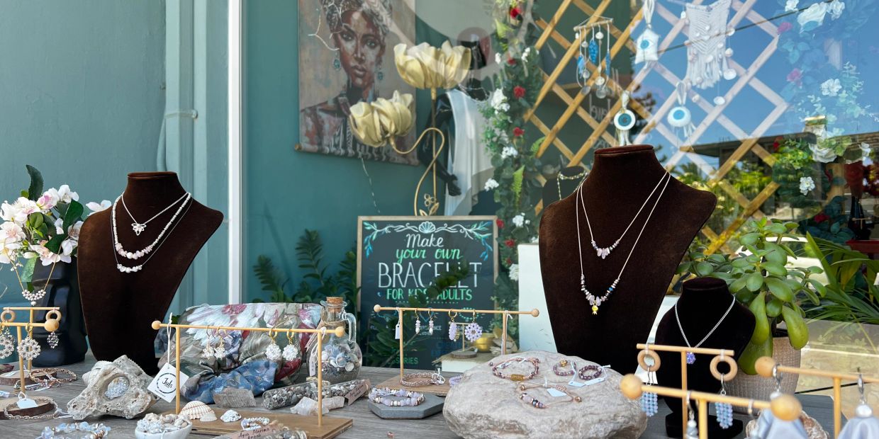 Jewelry display with necklaces, earrings, and bracelets in a creative store setting.